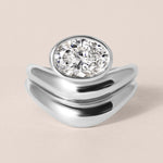 Top-down birds-eye view of Liora oval bezel engagement ring in white gold or platinum paired with a matching diamond contour band.