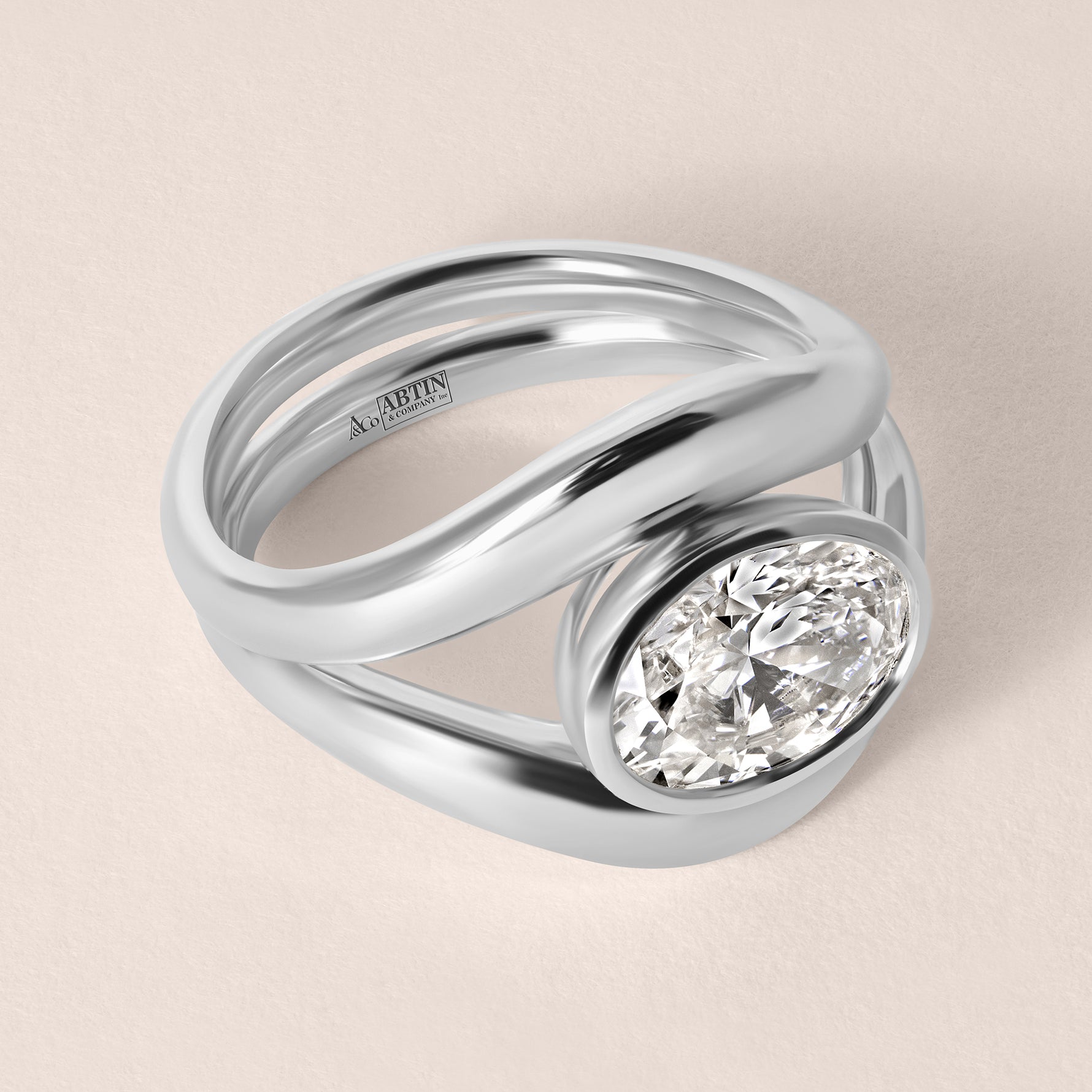 Three-quarter angled view of Liora oval bezel engagement ring stacked with a plain contour wedding band in white gold or platinum.
