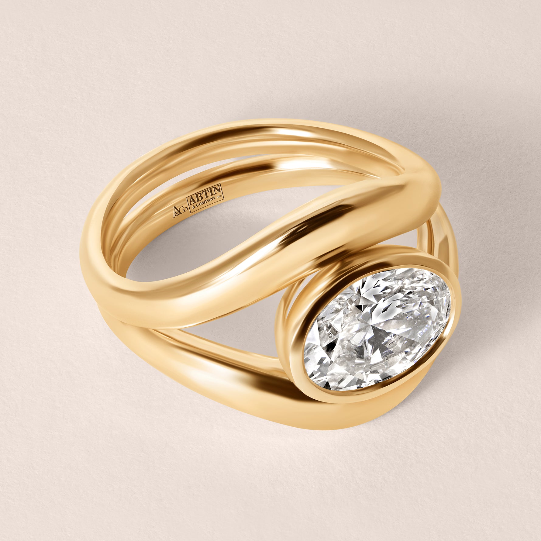 Three-quarter top view of Liora oval bezel engagement ring in 18K rose gold showing the elegant metal split-band design.