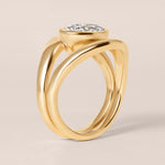 Side profile view of Liora oval bezel engagement ring in 18K rose gold highlighting the fluid architectural setting.