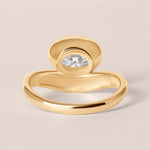 Back structural view of Liora oval bezel engagement ring in 18K yellow gold showcasing the solid under-gallery design.