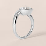 Side profile view of Liora oval bezel engagement ring in white gold or platinum highlighting the seamless bezel basket design.