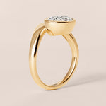 Side profile view of Liora oval bezel engagement ring in 18K yellow gold showing the high-polish low profile bezel setting.